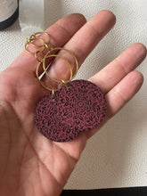 Load image into Gallery viewer, Close-up of burgundy wood dangle earrings with intricate dark mandala engraving
